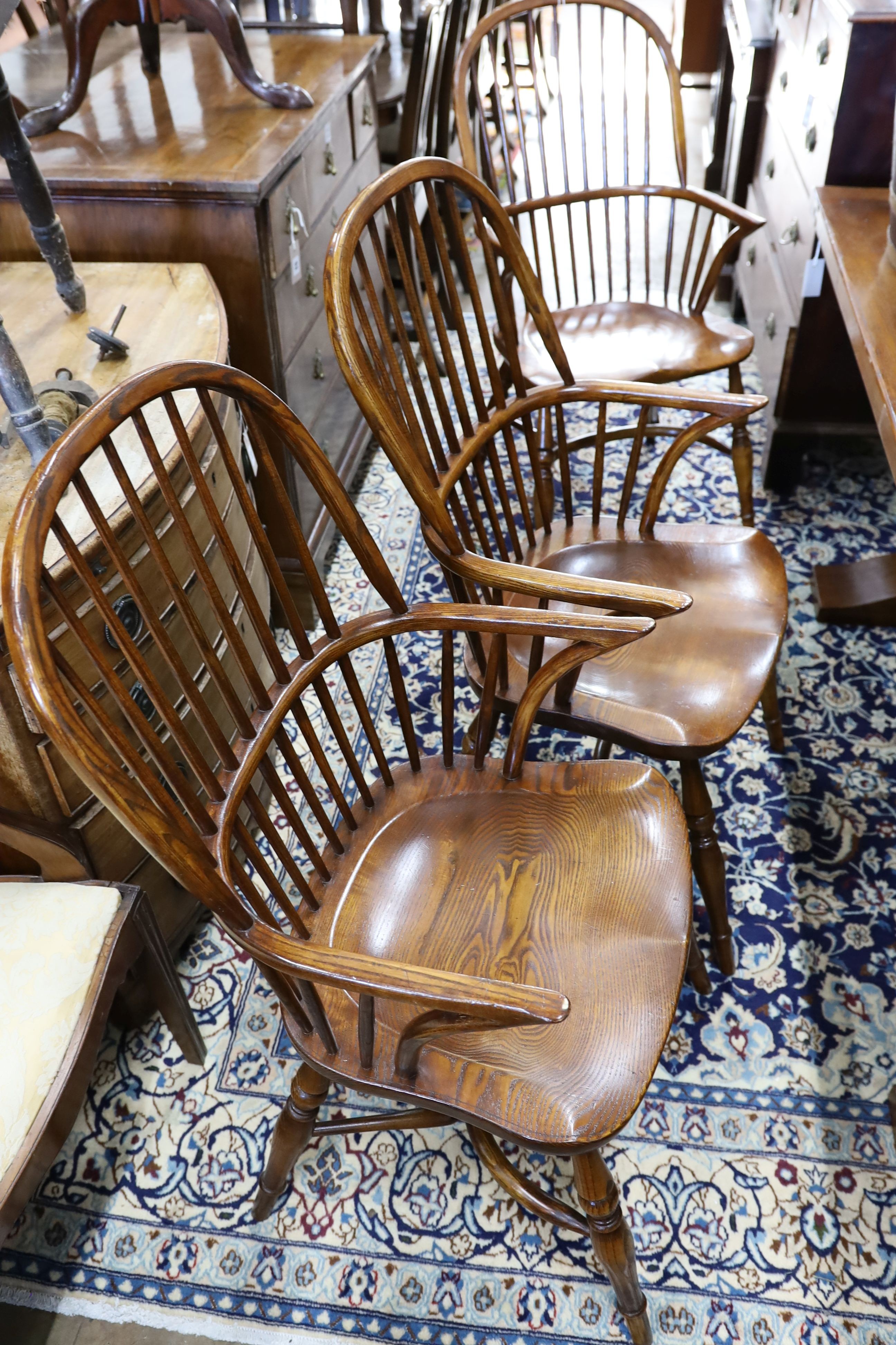 A set of six reproduction ash and elm Windsor comb back armchairs with saddle seats and crinoline stretchers, width 52cm, depth 45cm, height 102cm